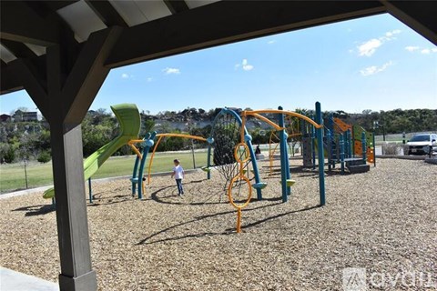 A playground with a green slide and a child playing.