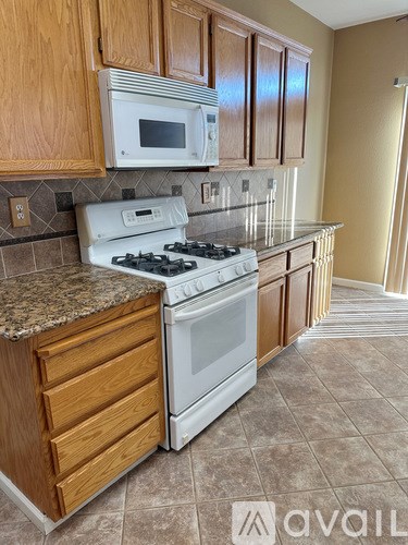 A kitchen with a white stove and wooden cabinets.