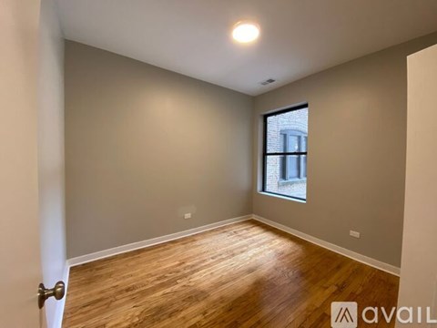 A room with wooden flooring and a window.