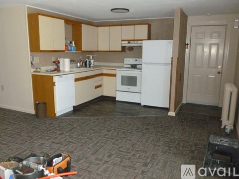A kitchen with white appliances and wooden cabinets.