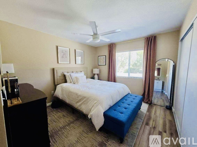 A bedroom with a bed, dresser, and window.
