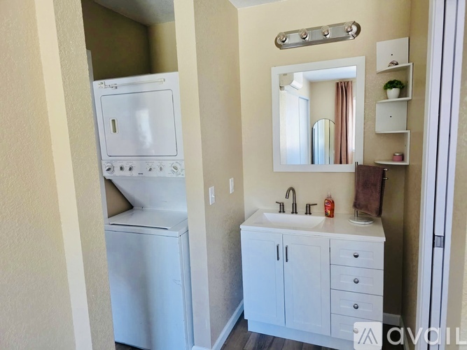 A small white kitchen with a washing machine and a sink.