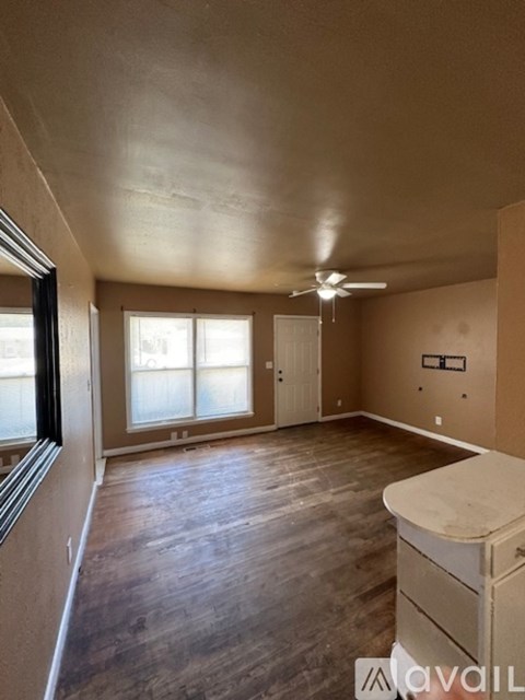 A room with wooden floors and a ceiling fan.