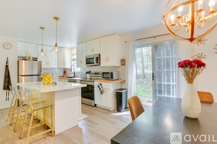 A kitchen with a table and chairs in front of a window.