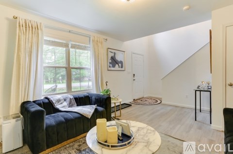 A living room with a black couch and a coffee table with candles on it.