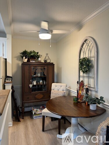 A dining room with a wooden table and chairs.