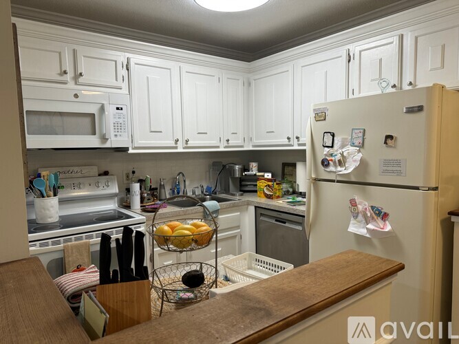 A kitchen with white cabinets and a wooden counter.