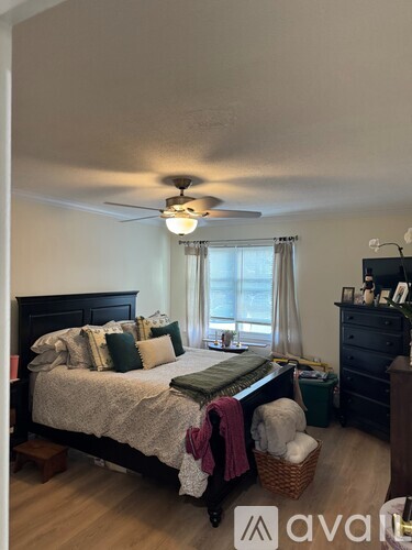 A bedroom with a bed, dresser, and window.