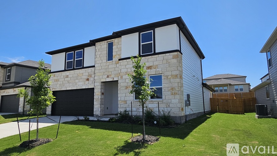 A modern house with a stone facade and a garage door.