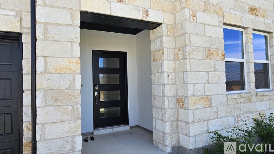 A stone house with a black door and window.