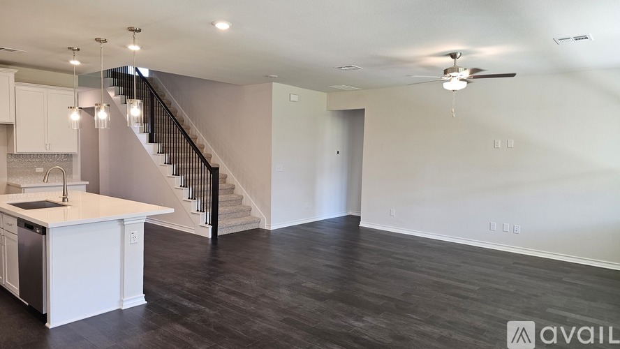 A spacious kitchen with a staircase leading to the upper floor.