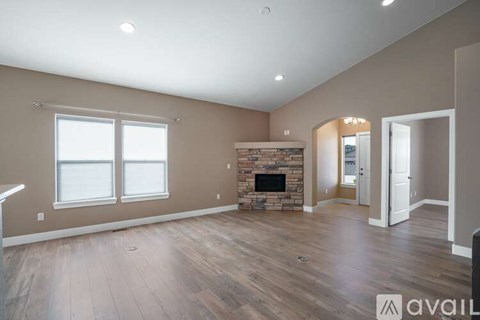 A spacious living room with a fireplace and hardwood floors.