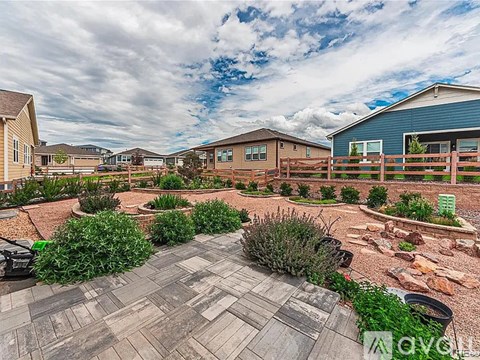 A large outdoor patio area with a stone walkway and a variety of plants.