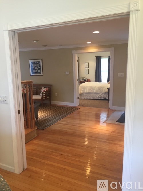 A bedroom with a bed and a dresser is visible through an open door.