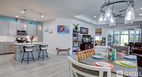 A modern kitchen with a dining table set for two.