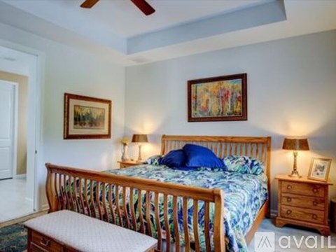 A bedroom with a bed, nightstand, and two lamps.