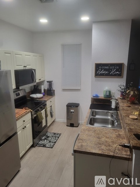 A kitchen with granite countertops and a fridge.