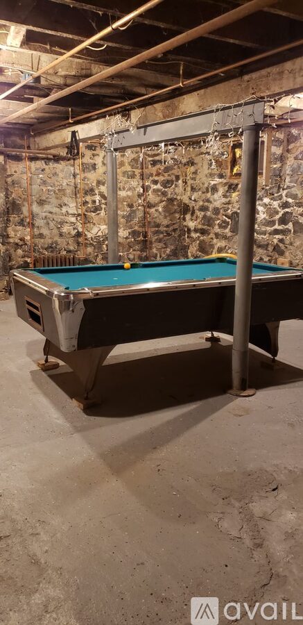 A pool table in a room with stone walls.
