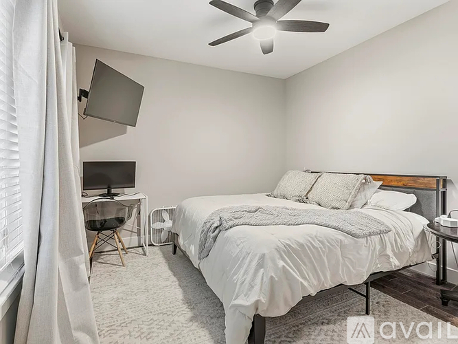 A bedroom with a large bed and a ceiling fan.