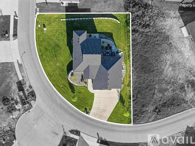 A bird's eye view of a property with a large building and a green lawn.