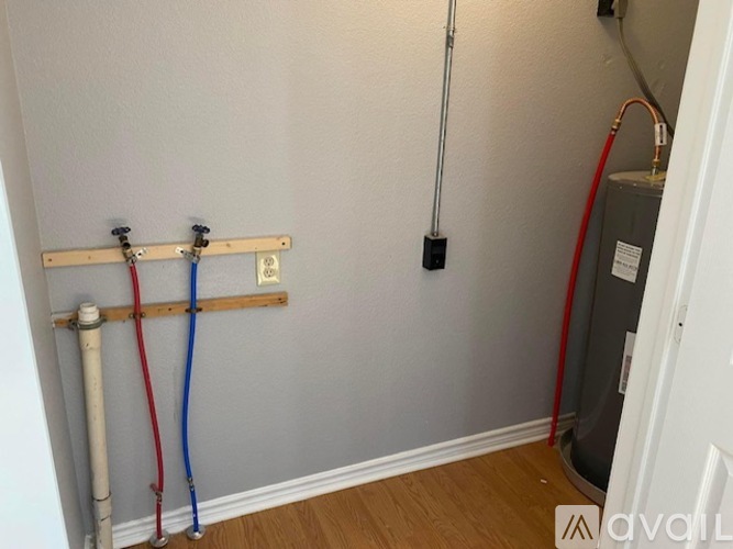 A wall with pipes and a heater.