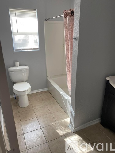A white toilet sits next to a bathtub in a bathroom.
