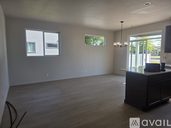 A spacious room with a cabinet and a chandelier.