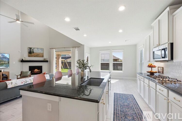 A modern kitchen with a black countertop and white cabinets.