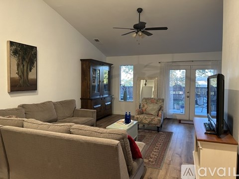 A living room with a grey couch and a painting on the wall.