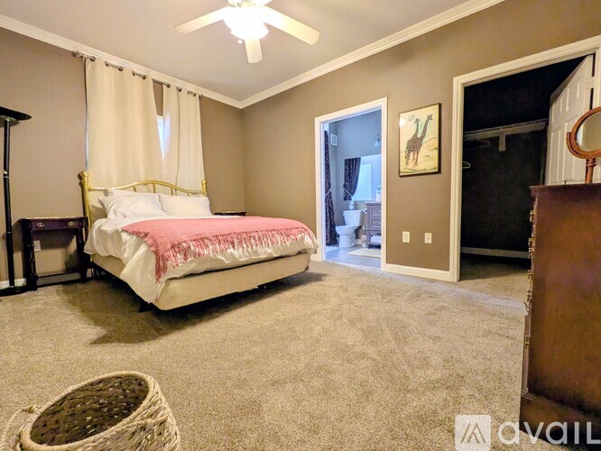 A bedroom with a bed, dresser, and a ceiling fan.