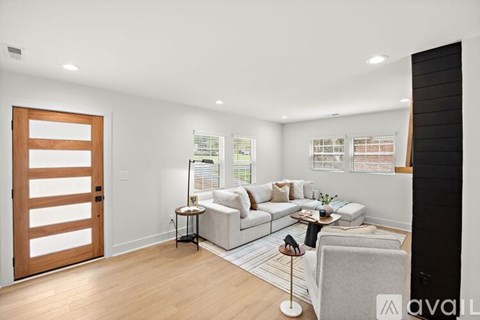 A modern living room with a white sofa and a wooden door.