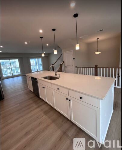 A kitchen with white cabinets and a wooden floor.