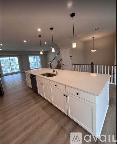 A kitchen with white cabinets and a wooden floor.