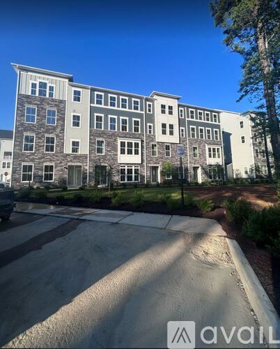 A large building with a lot of windows is in front of some trees.