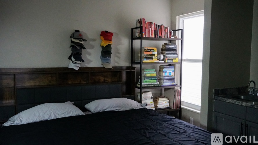 A bedroom with a bed, pillows, a bookshelf, and a window.