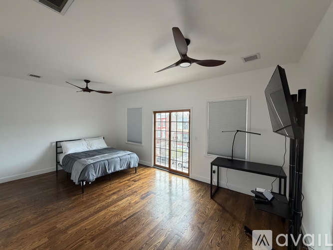 A bedroom with two beds and a television.