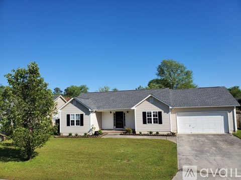 A house with a grey roof and a white garage door.