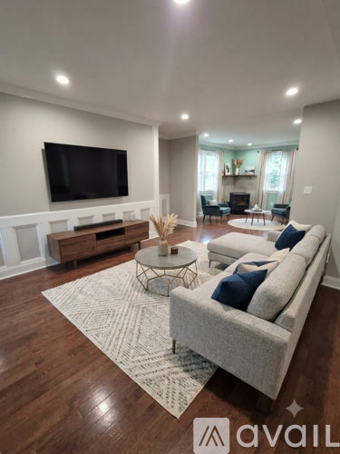 A spacious room with wooden flooring and white trim.