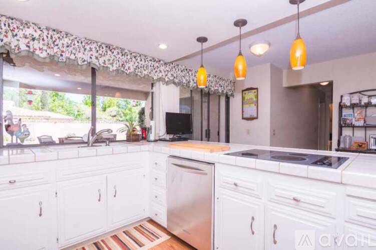 A kitchen with white cabinets and a wooden floor.