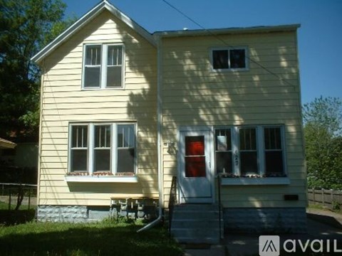 A two-story house with a red door and windows.