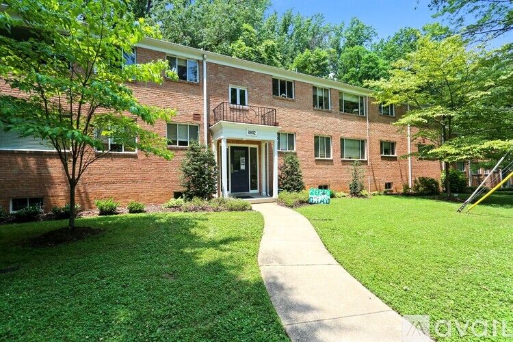 A brick building with a green lawn in front.