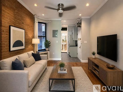 A living room with a couch, a coffee table, and a television.
