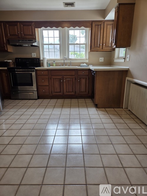 A kitchen with brown cabinets and a black stove top oven.