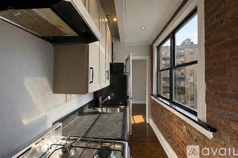 A kitchen with a stove top oven and a window.