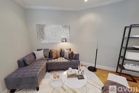 A living room with a grey sofa and a white coffee table.