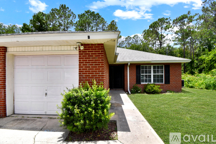 A house with a white garage door and a brick facade.