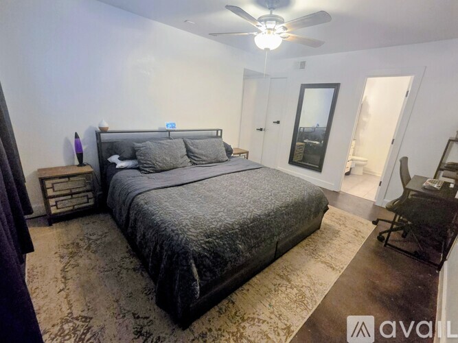A bedroom with a large bed and a ceiling fan.
