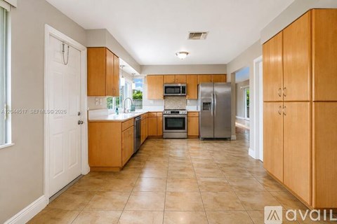 A kitchen with wooden cabinets and a tiled floor.