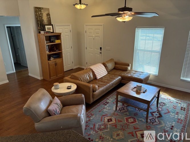 A living room with a brown leather couch and a wooden coffee table.