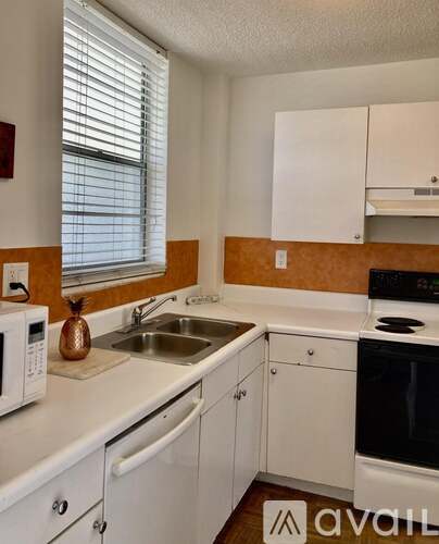 A kitchen with white cabinets and a black oven.